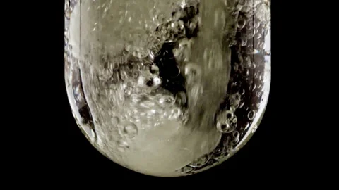 Macro Shot of Various Air Bubbles in Water in Glass Test tube Rising up on Black Stock Footage 261530752