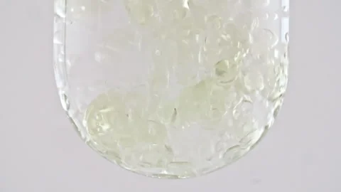 Macro Shot of Various Air Bubbles in Water in Glass Test tube Rising up on White Stock Footage 262776524