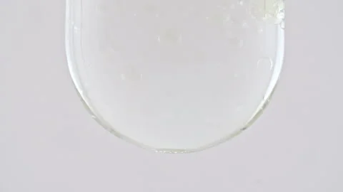 Macro Shot of Various Air Bubbles in Water in Glass Test tube Rising up on White Video stock 264578296