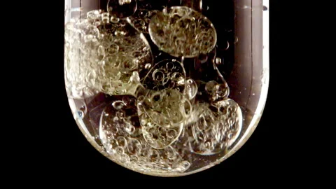 Macro Shot of Various Air Bubbles in Water in Glass Test tube Rising up on Black Stock Footage 265902646