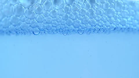 Macro shot of various air bubbles in water rising up on blue background. Sl.. Stock Footage 275888983