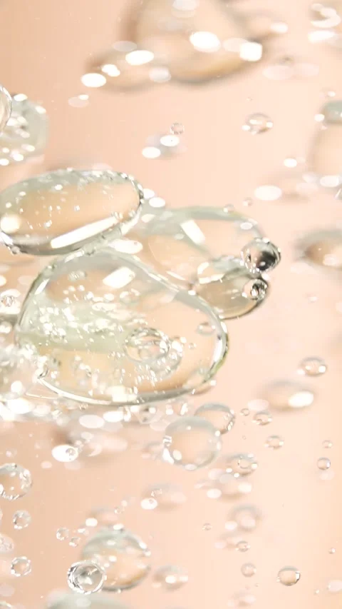Macro shot of various air bubbles rising up on beige background. Slow motion. Stock Footage 297863781