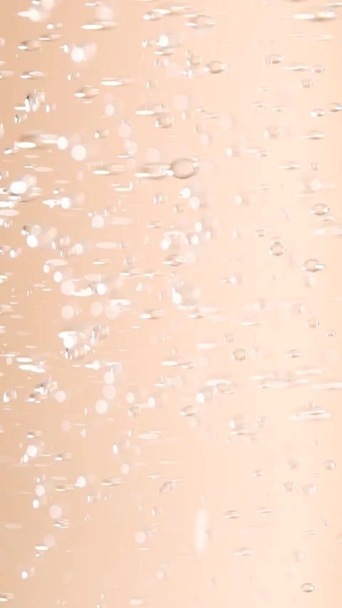 Macro shot of various oil bubbles in water rising up on beige background. S.. Stock Footage 297863778