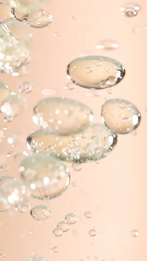 Macro shot of Various oil bubbles moution and rising up on beige background.. Stock Footage 300833582