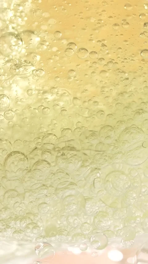 Macro shot of various oil bubbles in water rising up on beige background. S.. Stock Footage 300833595