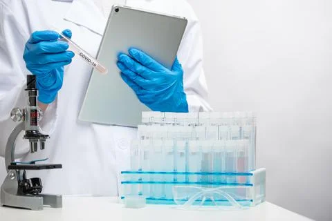 Macro shot view of microbiologist in protective gloves holds biological tubes Stock Photos