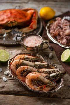 Macro shot view of plates with assorted seafood served with spices on rustic  Stock Photos