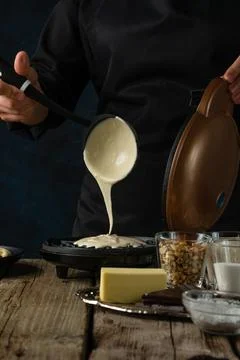 Macro shot view of process of pours dough on waffle maker machine for prepari Stock Photos