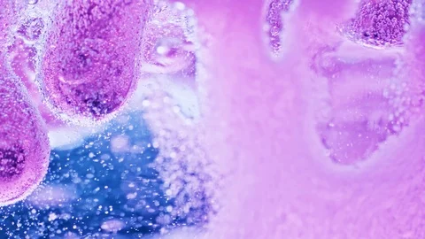 Macro shot of violet substance in water slowly dripping to ground with Video stock 124671229