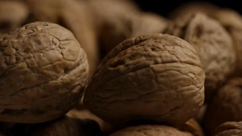 Macro shot of walnut shells rotating in dark light Stock Footage 328135971