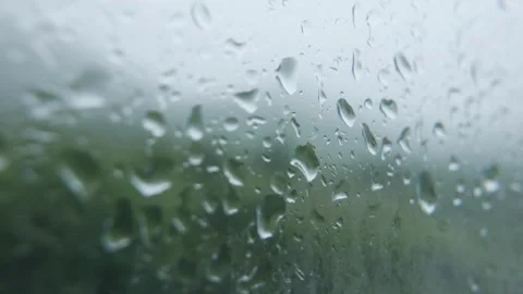 Macro shot of water droplets on window glass refracting daylight while gentle Vídeo Stock 320976778