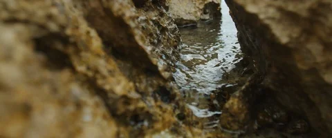 Macro shot of Water flow between rocks in slowmotion Stock-Footage 97898205