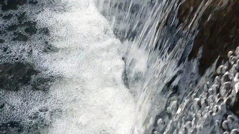 Macro shot of water flow falling down into water making foam in fountain slow mo Stock Footage 104229702