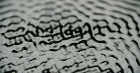 Macro shot of water surface vibrating to frequency. Water forming waves Vidéo 116721422