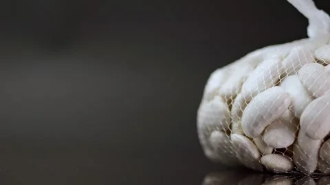 Macro shot of white beans turning gently, highlighting their detail against.. Stock Footage 262528012