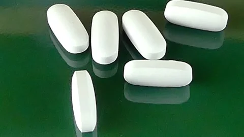 Macro Shot of White Elongated Tablets - Pharmaceutical Medicine Stock Footage 290793484