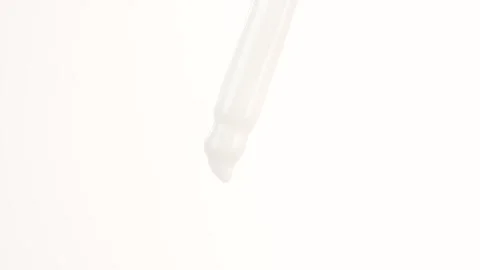 Macro shot of white moisturizing serum lotion falling from a glass pipette. Stock Footage 304461537