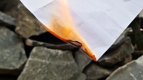 Macro Shot of White Paper Burning Between Rocks with Real Flames Stock Footage 333579000