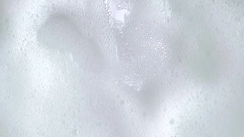 Macro shot of white soap suds flowing down of glass. Shower concept. Soap b.. Stock Footage 269323476