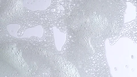 Macro shot of white soap suds flowing down of glass. Shower concept. Soap b.. Stock Footage 271230388