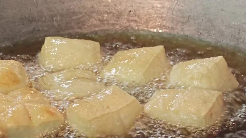 Macro shot of white tofu cubes deep frying in hot oil. Vidéo 344556262