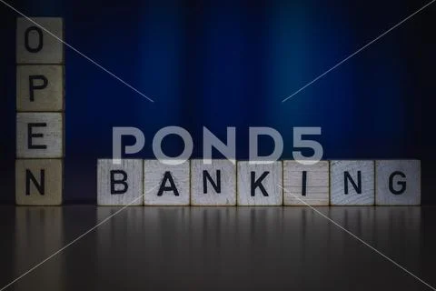 Macro shot of wooden cubes on a table showing words OPEN BANKING Stock Photos