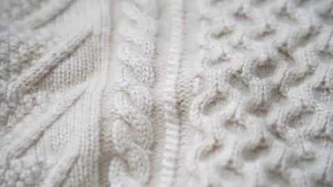 Macro shot of wool fabric sweater. Slider dolly close-up wool textile beige c Stock Footage 332603426