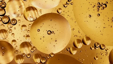 Macro shot, yellow gold bubbling oil round sphere water, brewery beer whiskey Stock Footage 128662392