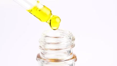 Macro shot of yellow moisturizing serum lotion in pipette falling in the bo.. Stock Footage 260702820