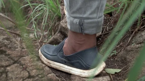 Macro shot of young man walking forward in nature indian with shoes sneekers Video stock 109611064