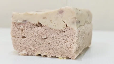 Macro side view of a soft taro chiffon cake slice with creamy taro fudge. Видео 348544905