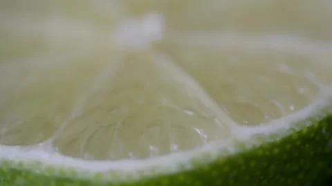 Macro of a slice of green lemon spinning Stock Footage 160556720