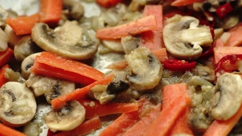Macro of sliced button mushrooms and carrots cooking in tasty garlic sauce Stock Footage 69184615