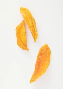 Macro slices of dried mango slice on white.Top view. Stock Photos