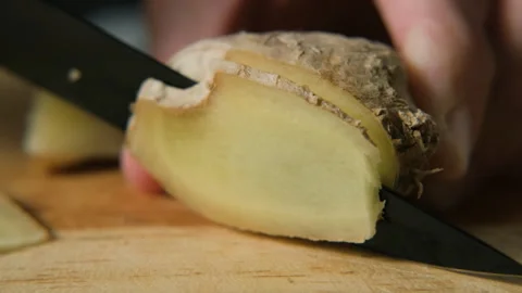 Macro slicing fresh ginger root showing texture Stock Footage 321952155