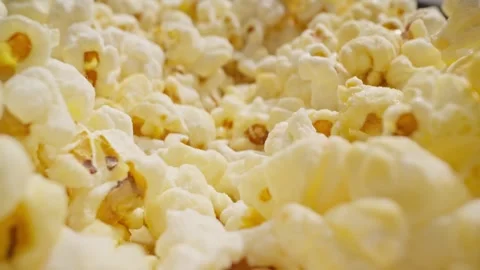 Macro slide dolly shot of popcorn. Camera moving out of delicious pop corn. Video stock 280674613