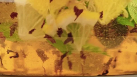 Macro slow motion. Herbal tea infusion of mint, ginger, lemon, black tea leaves Stock Footage 318888379