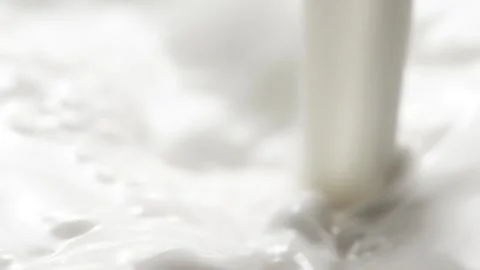 Macro slow motion pouring white milk, closeup splashing fresh drink with drops Stockbeeldmateriaal 250148534