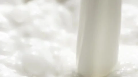 Macro slow motion pouring white milk, closeup splashing fresh drink with drops Stock Footage 252171370