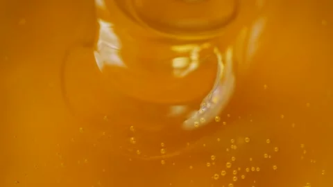Macro slow motion video of pouring brown honey, healthy vegetarian food texture Stock Footage 142009922