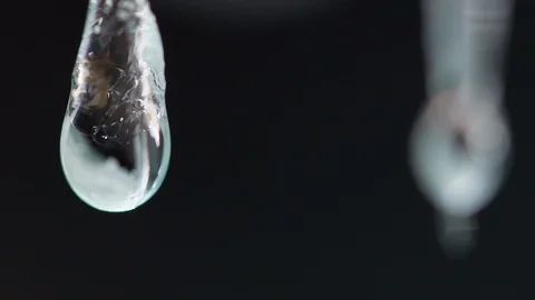 Macro slow motion video of pure water drop dripping from small icycles Stock Footage 91520317