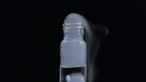 Macro smoke billows out of bubbling vial on black BG Stock-Footage 70706442