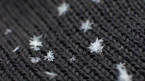 Macro Snowflake on black woolen mittens. UHD 4K video Stock Footage 100812336