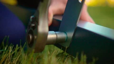 Macro socket wrench fastening bolt through gray steel support in grass. Close Stock Footage 333580505