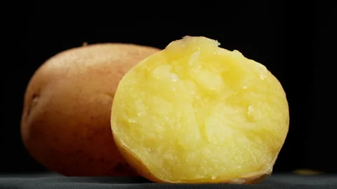 Macro Soft Cooked Yellow Boiled Potato Half on Black Stock-Footage 343947091