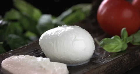 Macro of splashing liquid milk drops falling on fresh tomatoes and mozzarella Stock Footage 268982840
