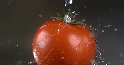 Macro of splashing water drops falling on fresh ripe organic single tomato Stock Footage 269353364