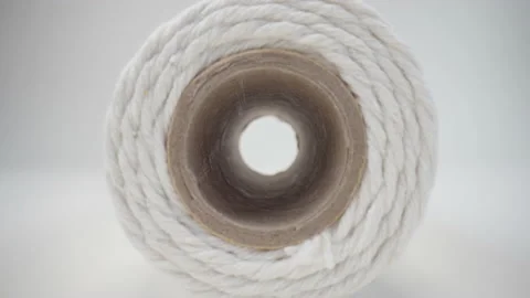 Macro spool rope white background. Slider dolly extreme close-up roll of thread Stock Footage 233602564