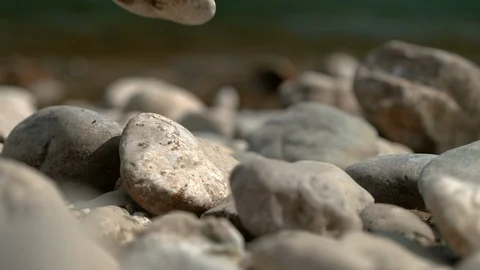 MACRO: Stone breaks and shatters into pieces after falling onto the riverbank. Stock Footage 120871514