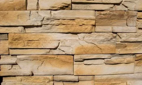 Macro of stone brick work. Modern interlocking brick pattern of an exterior wall Stock Photos
